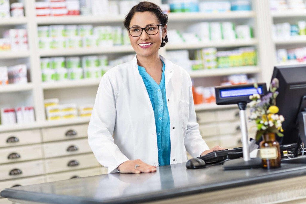 Smiling pharmacist welcoming community pharmacies to register
